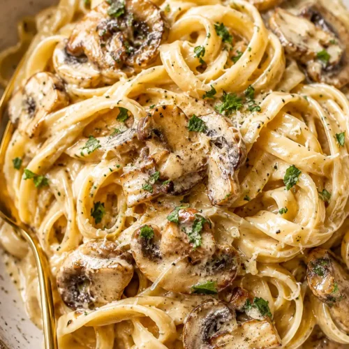Cremige Champignon Frischkäse Pasta mit Petersilie auf einem Teller serviert