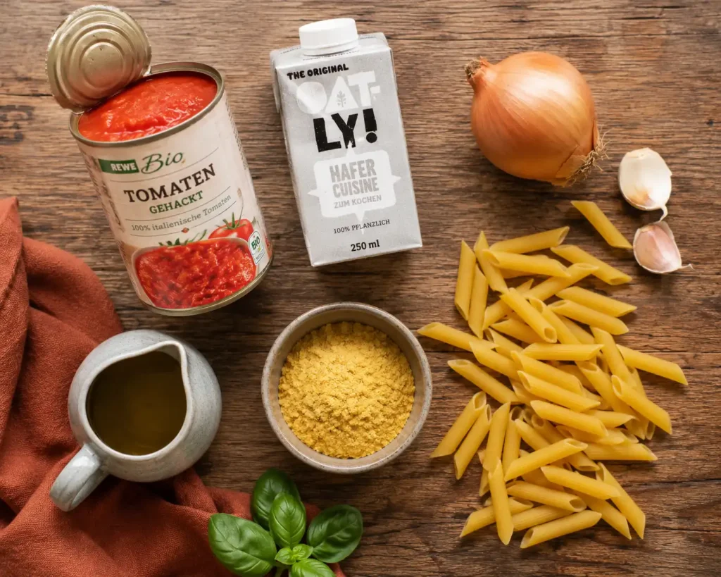 Zutaten für vegane Tomaten Pasta: Tomaten, Hafercreme, Zwiebel, Knoblauch und Pasta